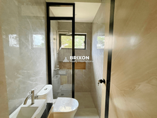 Compact bathroom with toilet, sink, and shower area