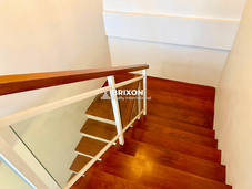Staircase with wood steps and metal railing, connecting to upper floor family area