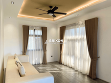 Second-floor family area with curtain-draped windows