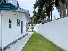 Side walkway of the house with paved flooring and boundary wall.