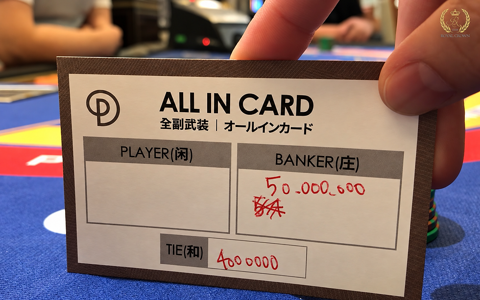 手で持たれたバカラのALL IN CARD。PLAYER、BANKER、TIE欄があり、BANKERに赤字で50,000,000、TIEに4000000。青い卓上。