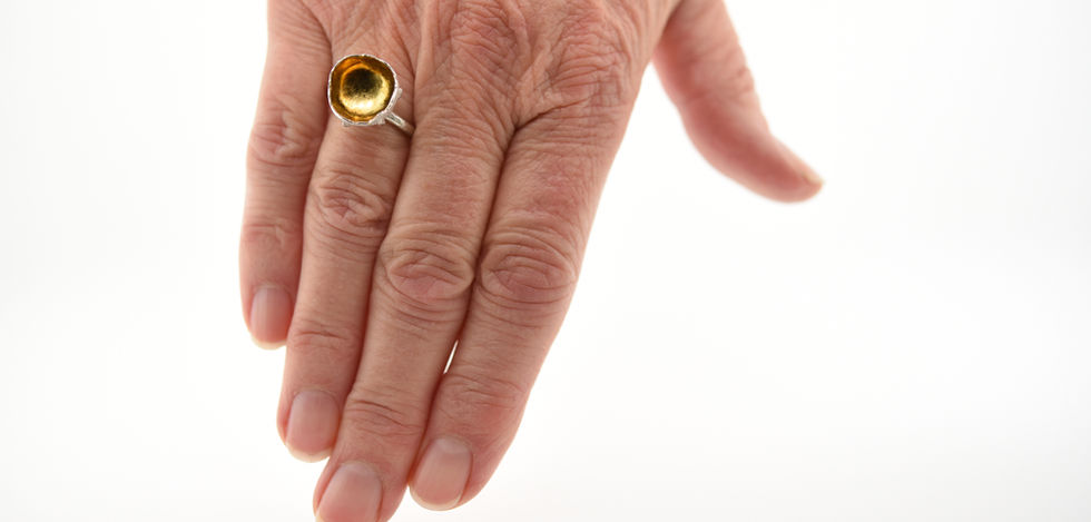 ring, zilveren kelkring bladgoud binnenin gedragen aan de hand