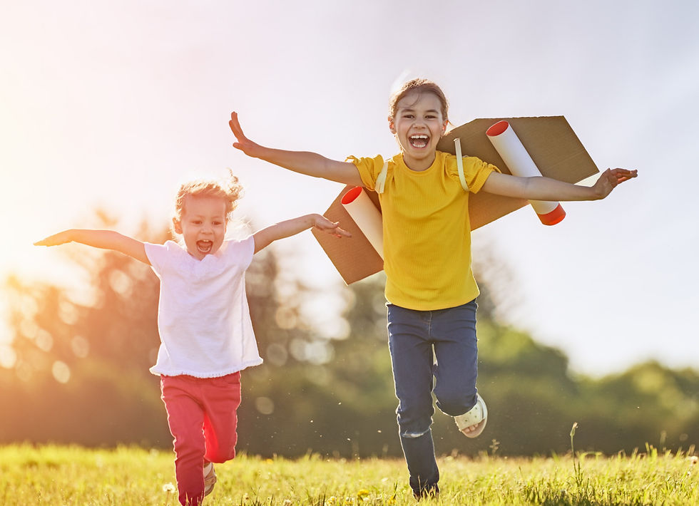 Two kids are running and playing, with their hands up in the air.