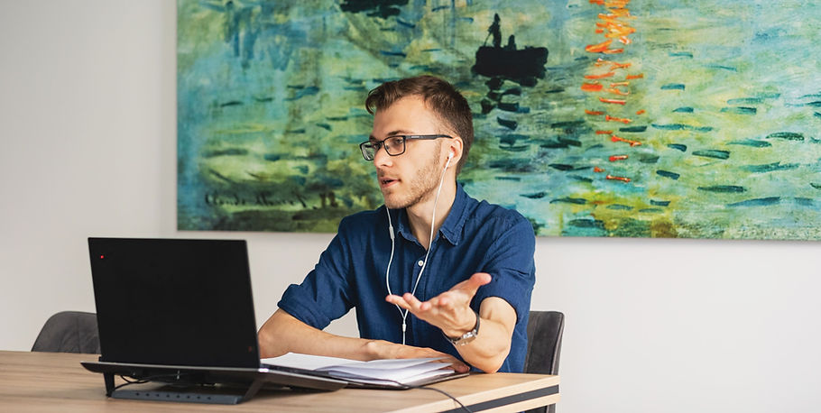 A man with a blue shirt and Monnet's painting behind having a video call