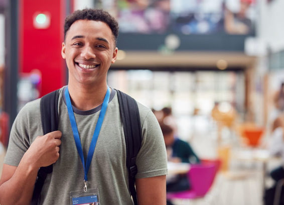 portrait-of-smiling-male-college-student-in-busy-communal-campus-building.jpg
