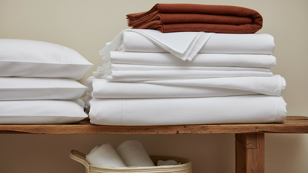 Close-up view of neatly folded white hotel bedding stacked in storage
