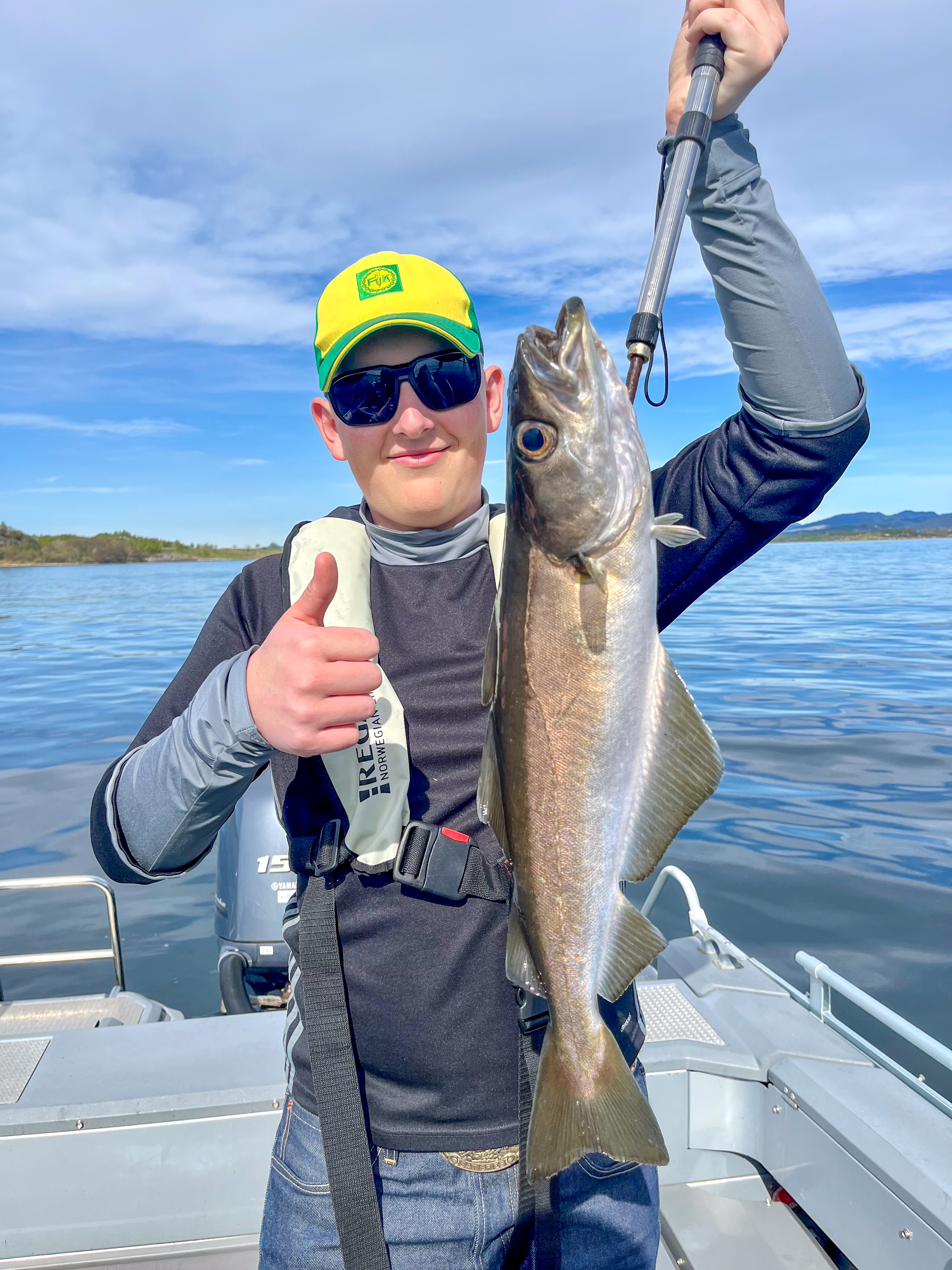 Guest holding a cod on a private guided fishing trip in sheltered coastal waters near Stavanger
