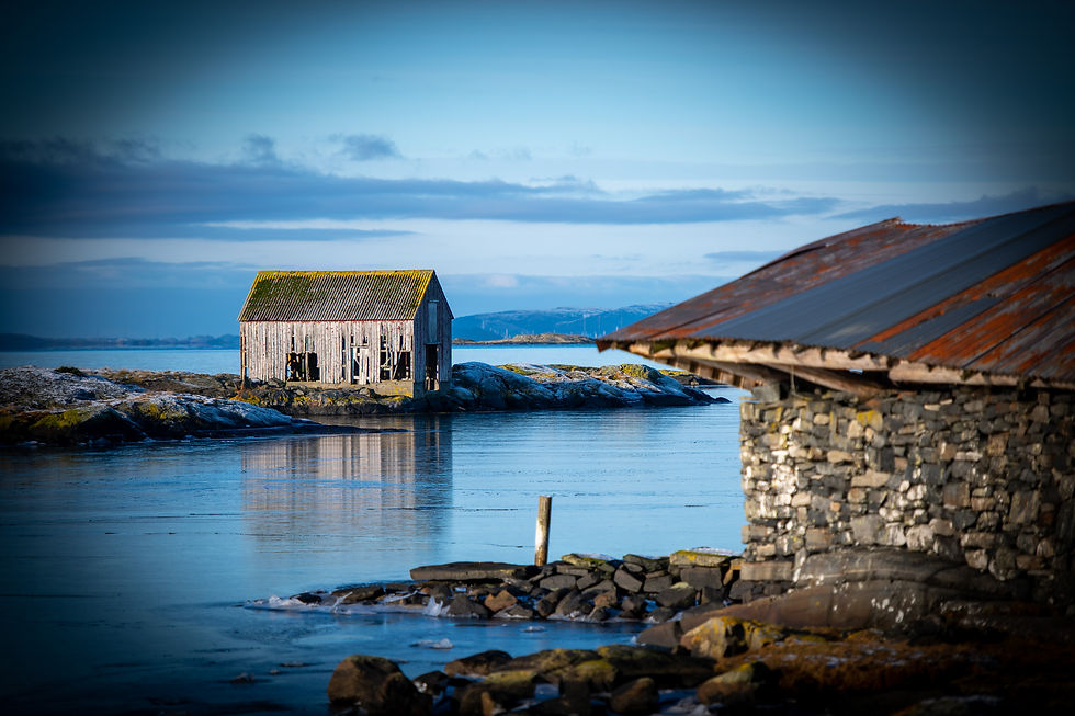 Traditional coastal buildings along the shoreline near Stavanger, visited on a private fjord tour.