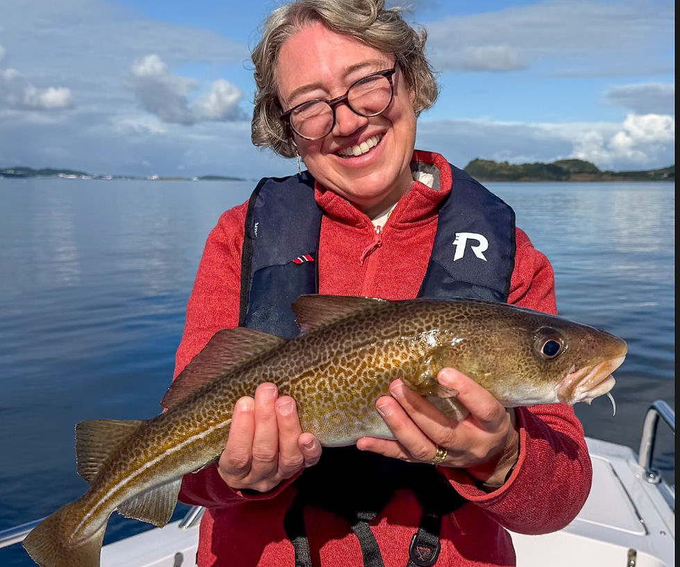 Guest holding a cod caught during a private evening fishing trip near Stavanger