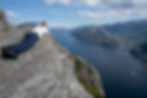 iker resting at the edge of The Hat summit with panoramic views over the Lysefjord