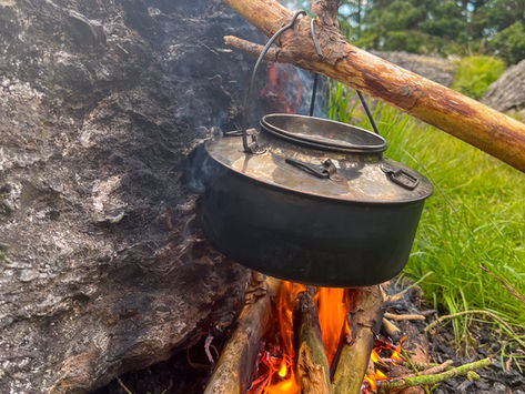 Coffee pot hanging over a campfire during a nature experience in Norway.