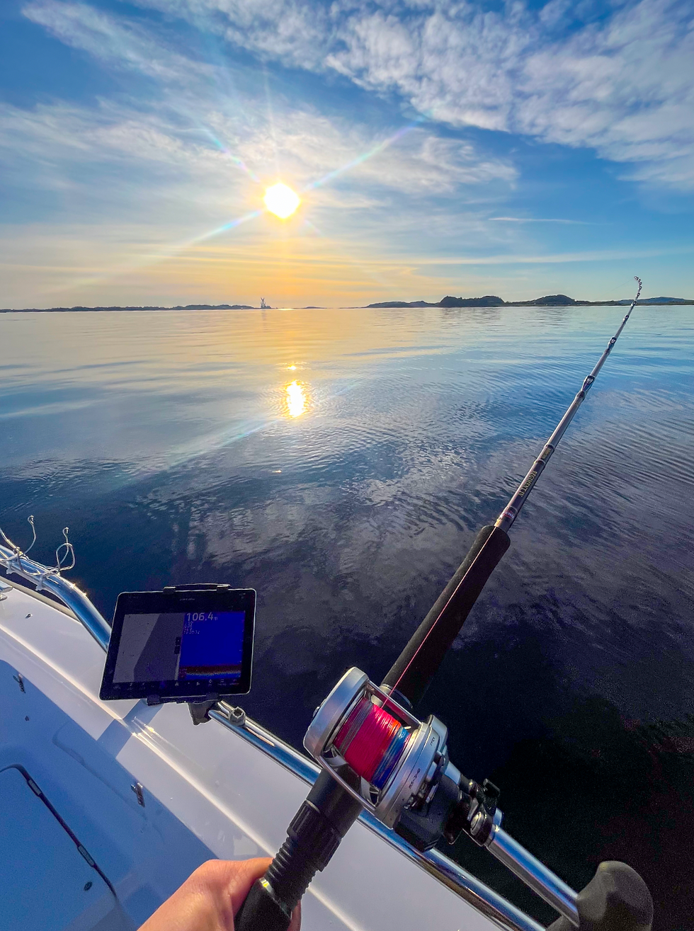 Deep water Stavanger fishing setup with Penn Fathom reel and Penn Regiment IV Halibuster rod — sonar displayed on iPad for real-time fish tracking in calm fjord conditions
