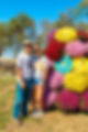 A couple posing in front of a Mazing Acres mum photo op