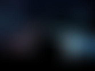 Human and robot hands reaching towards each other in a dark setting, evoking a connection between technology and humanity.