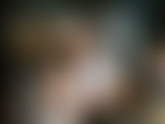 A couple standing at the top of the ceremony aisle, holding hands. An archway with draping and autumnal flowers decorate it. The bride has a matching flower crown.