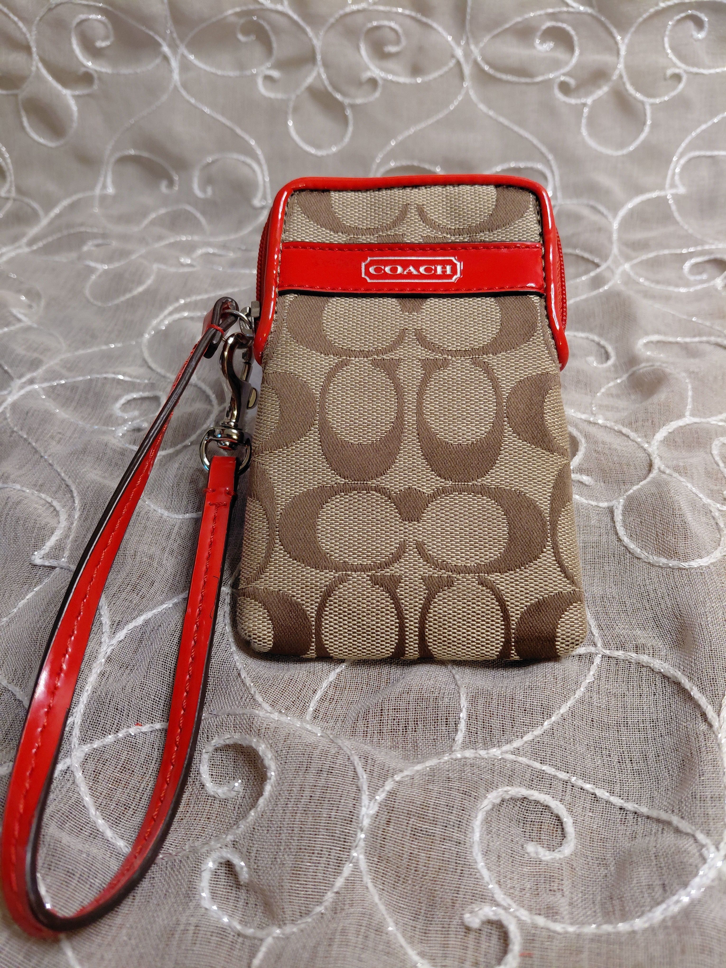 Coach khaki Signature jacquard phone wristlet with red patent leather trim and wrist strap