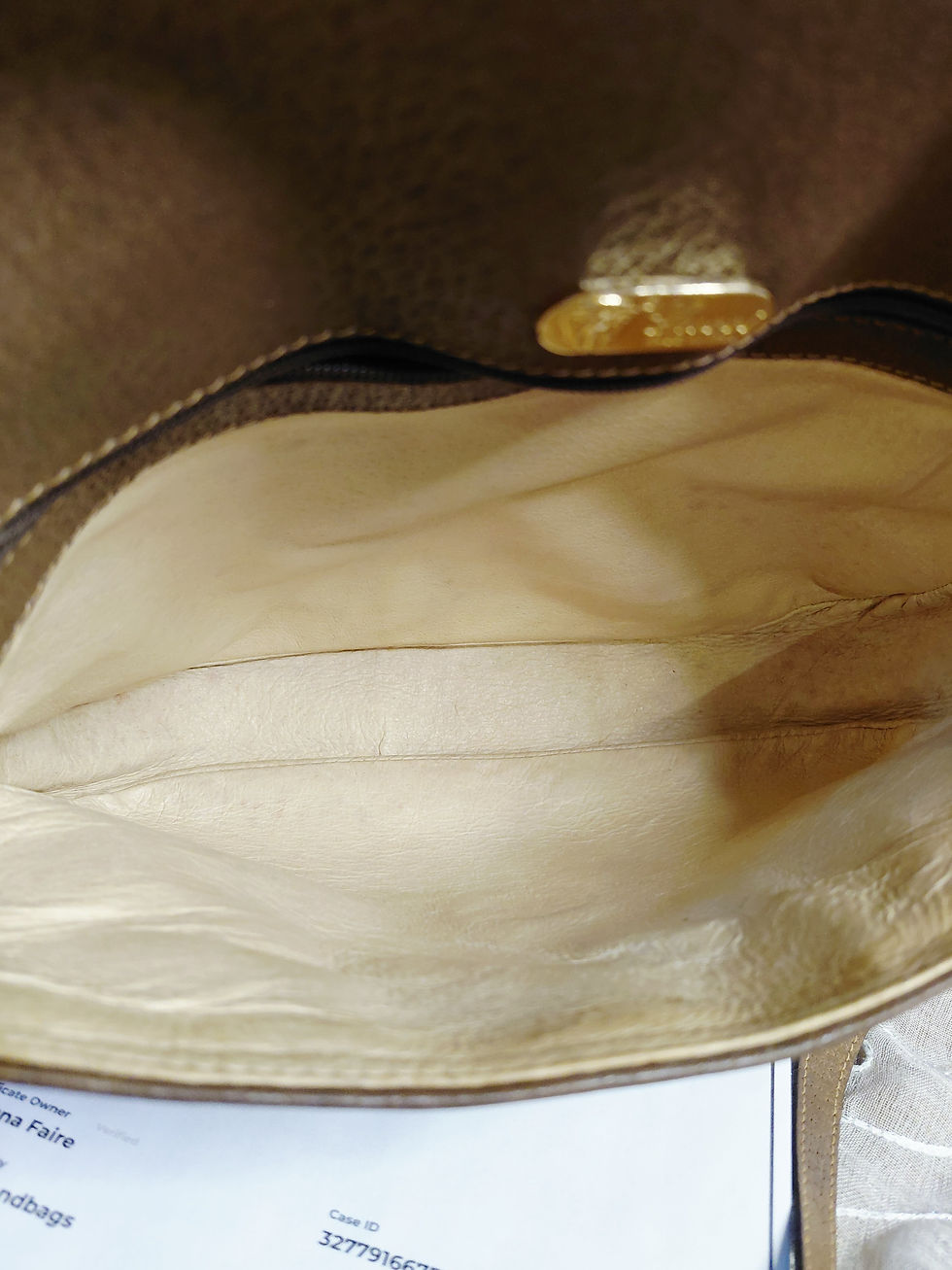 Thumbnail: Clean pale leather interior of vintage Gucci crossbody with interior zip pocket and gold-tone Gucci plaque.