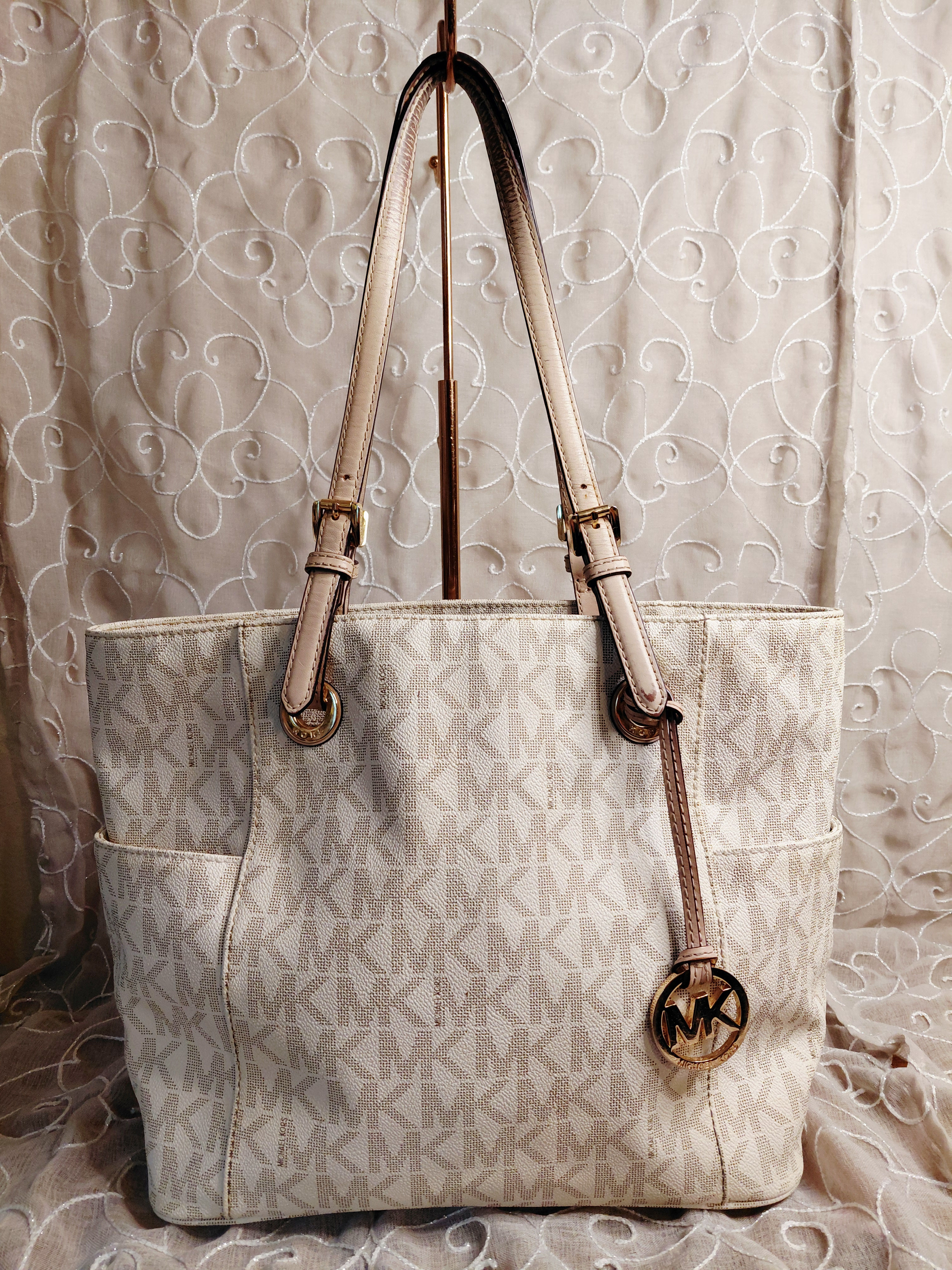 Michael Kors vanilla signature tote with cream leather straps, gold-tone hardware and hanging MK medallion charm.
