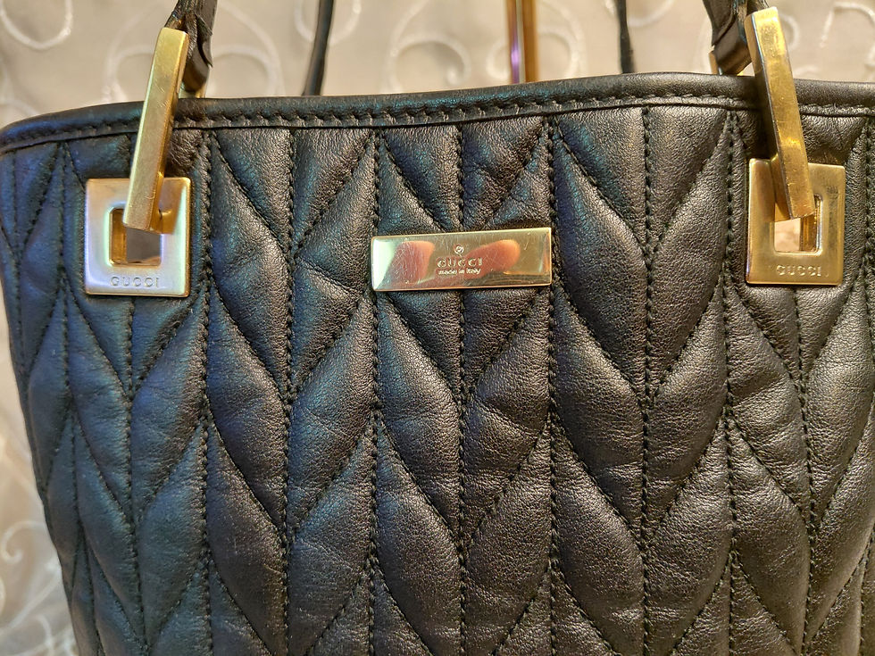 Thumbnail: Close-up of vintage Gucci mini tote showing sculptural gold-tone handle attachments, front plaque, and quilted leather.