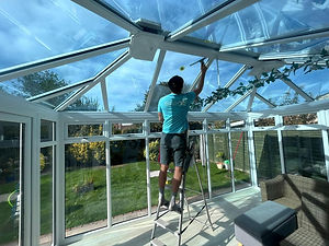man cleaning the ceiling of a conservatory