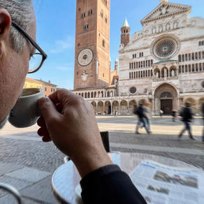 Savoring a morning espresso, Alessandro Di Matteo enjoys the serene view of Piazza Del Duomo in Cremona, Italy.