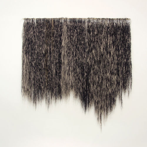 Large hand-knotted shaggy, furry fiber art wall hanging in black and natural wheat colors.
