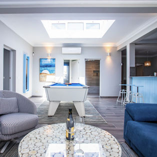 
Open plan living space with pool table, seating area and skylight
