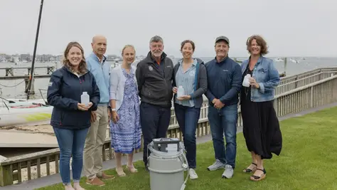 A group of people standing with water sampling equipment