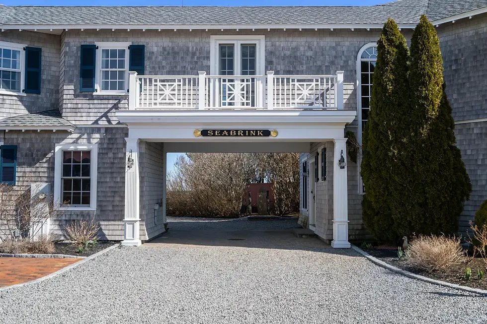 Building with grey shingles, an archway, and a sign 'BOARDING'