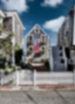 Charming coastal houses with cedar siding and American flag decoration