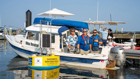 A group of three people standing on a boat docked in the harbor