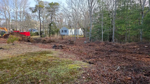 Cleared residential lot with trees and construction equipment