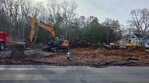 Excavator clearing a wooded residential lot for construction