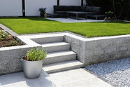 Neat and tidy garden with granite wall and solid block steps.jpg