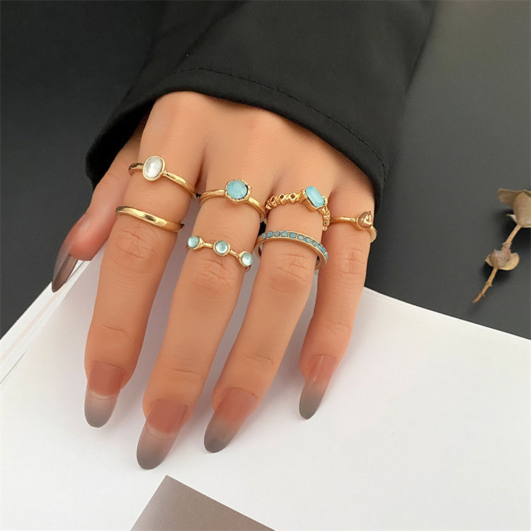 Miniature : Hand model wearing seven turquoise and gold rings