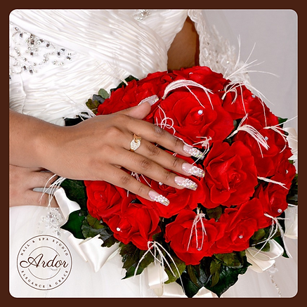 Manicure sposa con dettagli di perle e decorazioni eleganti su unghie lunghe, accompagnata da un bouquet di rose rosse, press