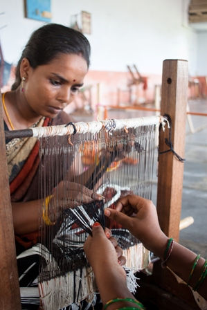 Picture of a woman threading a small weaving loom