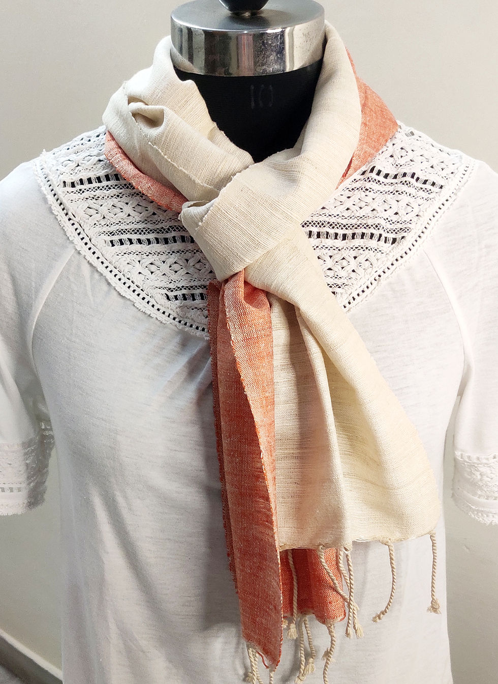 Thumbnail: Peach and natural coloured eri silk scarf tied around the neck of a mannequin
