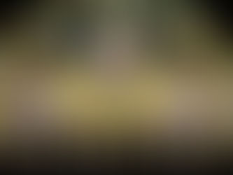 Szenenbild aus dem Film Samsara – Frau in goldener Kleidung mit stilisierten Armen im Hintergrund