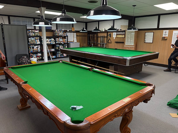 6x12 snooker table refelting and 4x8 pool table refelting completed in a recreation room with green billiard cloth.