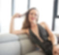 Brunette lady with pink lipstick looking directly at the camera being cheeky wearing black plunging sparkling dress one hand playing with her hair