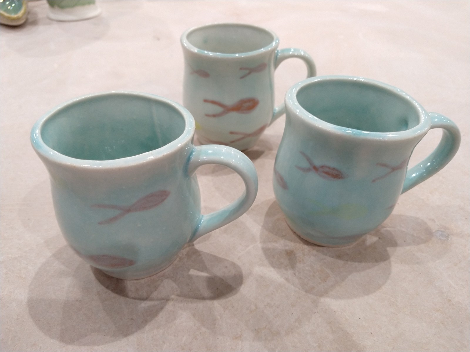 Three slip cast mugs with underglaze col
