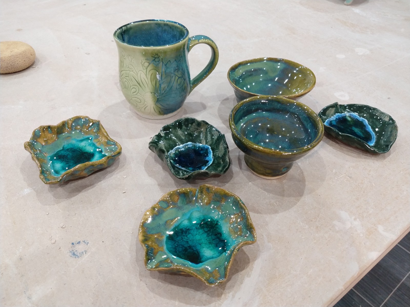 A slip cast mug and small bowls with gla