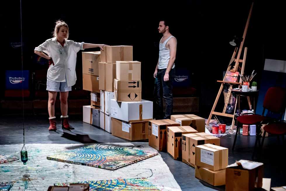 Scenografie realizată de Mădălina Sandu pentru spectacolul „Inundația”, regia Luana Hagiu, Teatrul „Maria Filotti” Brăila, 2021. Un decor inspirat dintr-un atelier de pictură, unde arta și relația umană se întrepătrund prin culoare și lumină.