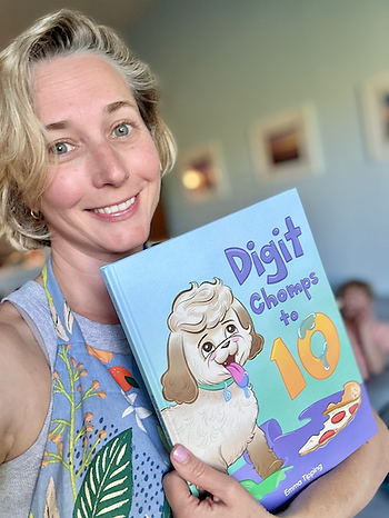 Author and illustrator Emma Tipping holding a copy of her book, Digit Chomps to 10, a counting book for preschoolers and kindergarteners.