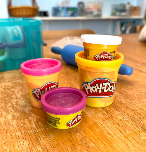 Photo of items on art supplies checklist, including Hasbro Playdoh pots.