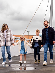 The Campbell Family - a family modelling shot with two parents with happy expressions surrounded by their two children, their daughter with styled blonde hair, their son with short blonde hair, all together outside, represented by ROC Talent Agency UK