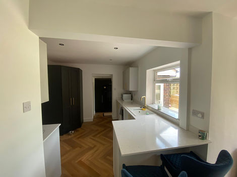 This contemporary kitchen showcases our crisp and clean painting finish throughout. The smooth white walls and ceiling create a bright, fresh feel that complements the modern cabinetry and golden accents. Our precise cutting-in and surface preparation ensure a flawless result, adding to the sleek aesthetic of the space. A perfect demonstration of how professional decorating enhances both natural light and modern design.