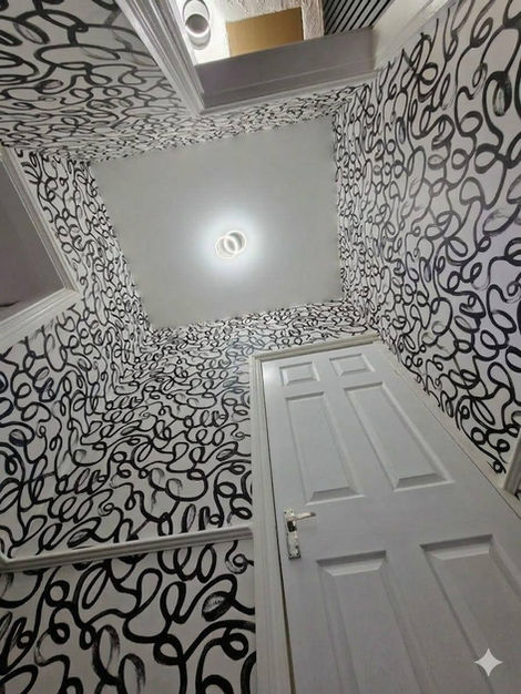 Upstairs hallway and stairway decorated with Squiggle wallpaper, combining bold graphic styling and continuous pattern flow for a striking and cohesive interior transformation.