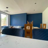 A striking transformation through our professional painting and decorating. This dining room features a bold navy accent wall, professionally finished for a flawless, modern look. The contrast against crisp white walls highlights the precision of our decorating work, bringing out the richness of the furnishings and the texture of the interior design.
Perfect example of how a professional paint job can elevate a space.